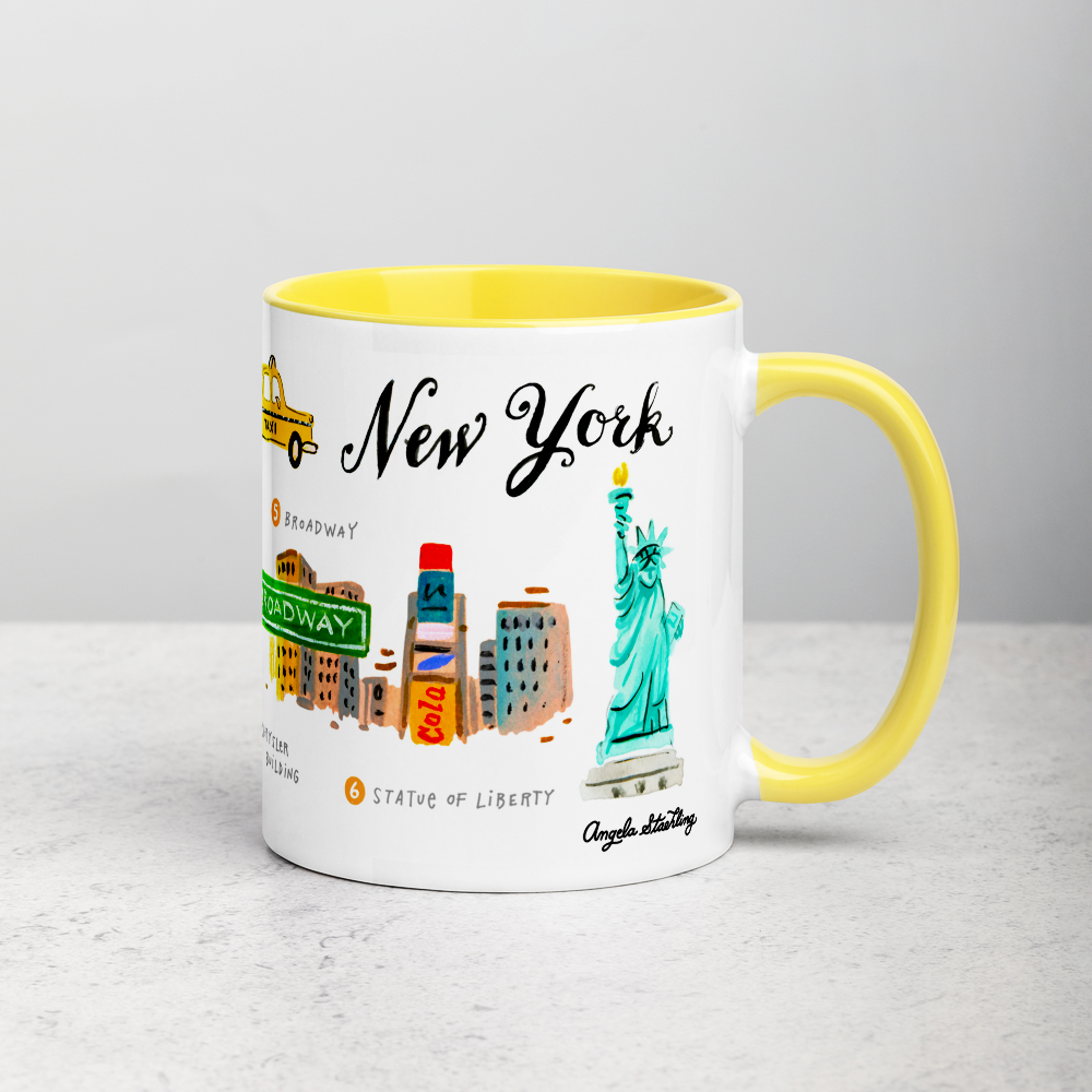 White ceramic coffee mug with yellow handle and inside; has New York landmarks illustration by Angela Staehling