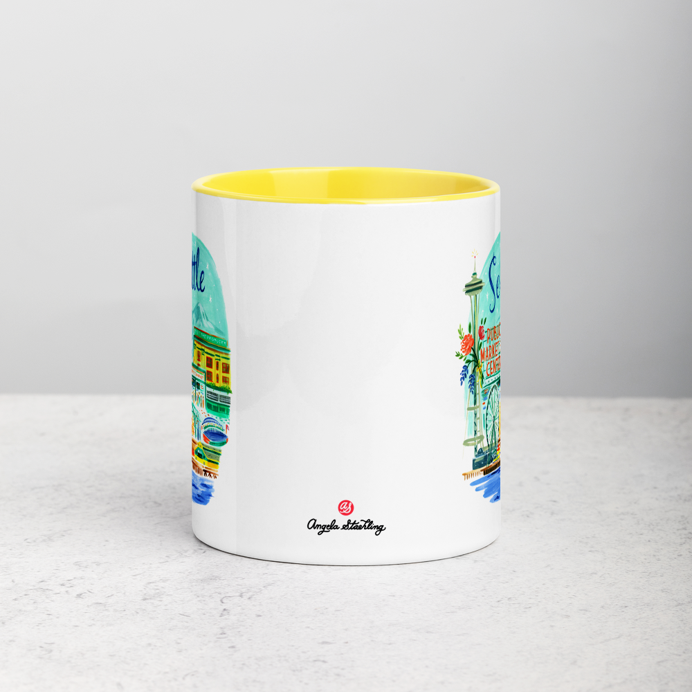 White ceramic coffee mug with yellow handle and inside; has Seattle Washington illustration by Angela Staehling